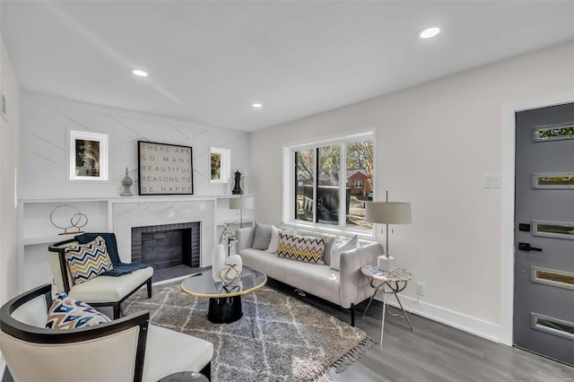 7449 Wayne Ave, Saint Louis, MO 63130 - living room featuring wood finished floors, baseboards, recessed lighting, and a brick fireplace