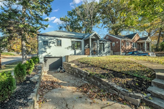 7449 Wayne Ave, Saint Louis, MO 63130 - back of property with a garage, driveway, and brick siding
