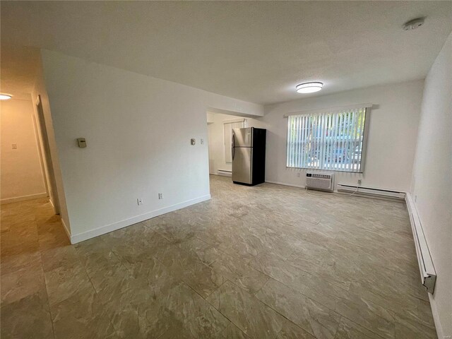 empty room with baseboard heating, an AC wall unit, and a smoke detector