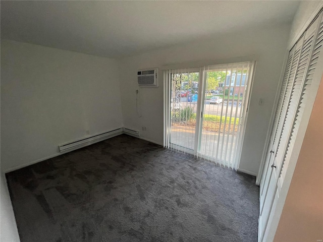 empty room with baseboard heating, dark carpet, a wall unit AC, and baseboards