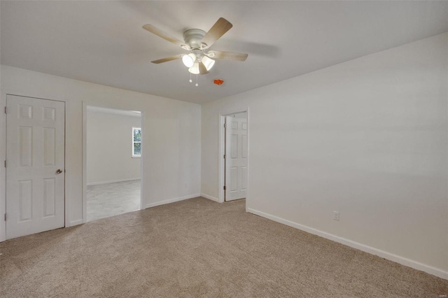 empty room featuring carpet, a ceiling fan, and baseboards