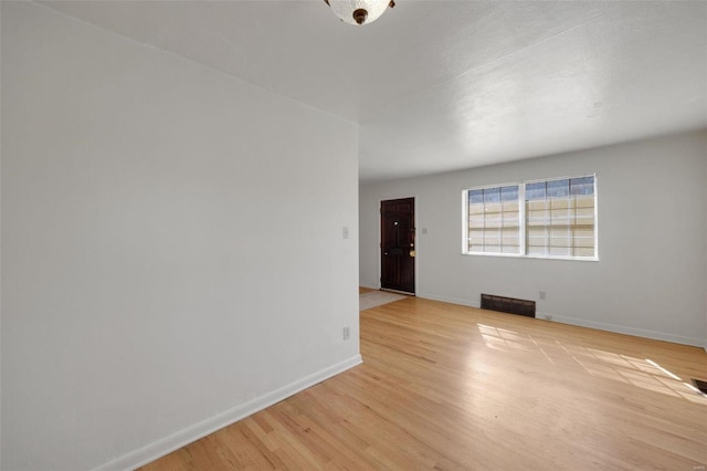 spare room with light wood-type flooring and baseboards