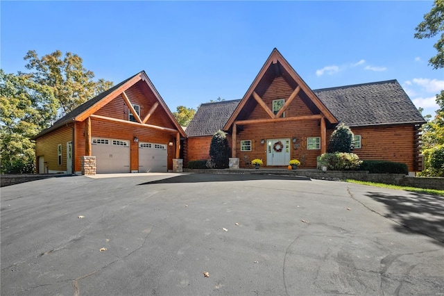 6800 Promise Pt, House Springs, MO 63051 - log home with asphalt driveway, an attached garage, and stone siding