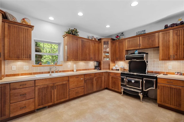6800 Promise Pt, House Springs, MO 63051 - kitchen featuring a sink, brown cabinets, decorative backsplash, light countertops, and recessed lighting