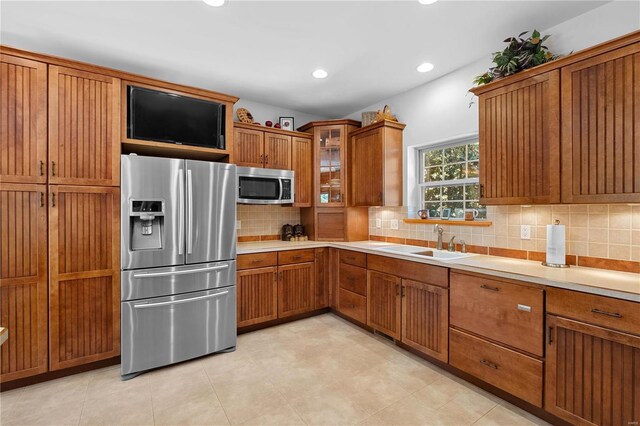 6800 Promise Pt, House Springs, MO 63051 - kitchen with appliances with stainless steel finishes, a sink, brown cabinetry, tasteful backsplash, and light countertops