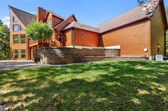 6800 Promise Pt, House Springs, MO 63051 - view of side of property with log siding, a yard, a patio, a chimney, and central air condition unit
