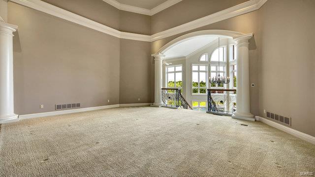 962 Hwy W, Foristell, MO 63348 - carpeted empty room featuring decorative columns, a towering ceiling, baseboards, ornamental molding, and arched walkways