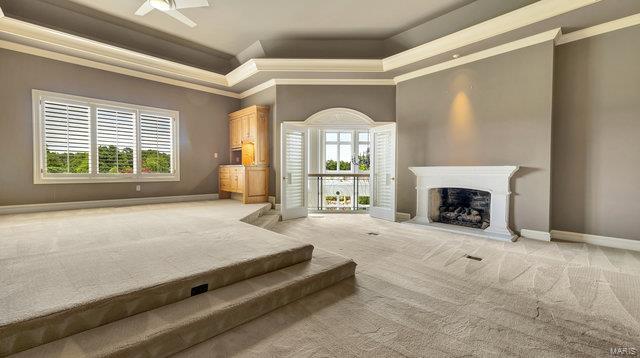 962 Hwy W, Foristell, MO 63348 - living room with a tray ceiling, light colored carpet, crown molding, baseboards, and a fireplace with raised hearth