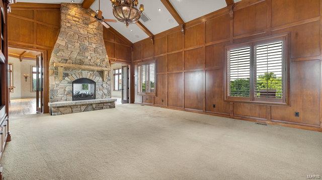 962 Hwy W, Foristell, MO 63348 - unfurnished living room with beam ceiling, a stone fireplace, high vaulted ceiling, carpet, and a chandelier