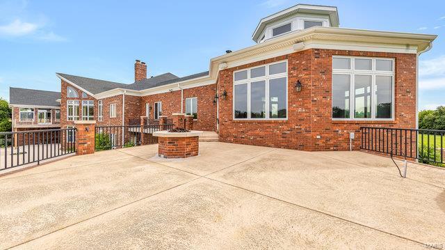 962 Hwy W, Foristell, MO 63348 - rear view of property featuring brick siding, a patio, a chimney, and fence