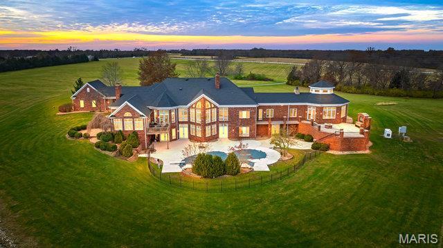 962 Hwy W, Foristell, MO 63348 - back of house at dusk with a patio, stairs, and a view of rural / pastoral area