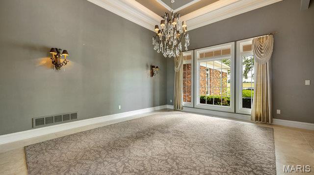 962 Hwy W, Foristell, MO 63348 - spare room with crown molding, a chandelier, a towering ceiling, and a raised ceiling
