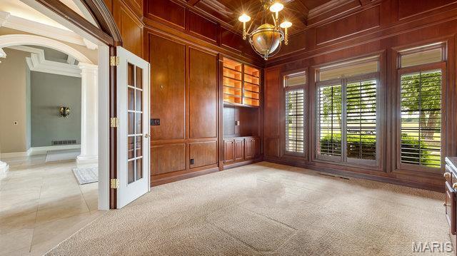 962 Hwy W, Foristell, MO 63348 - unfurnished room featuring ornate columns, crown molding, a chandelier, arched walkways, and wood walls