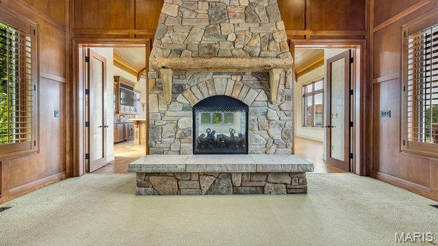 962 Hwy W, Foristell, MO 63348 - carpeted living area featuring wood walls and plenty of natural light