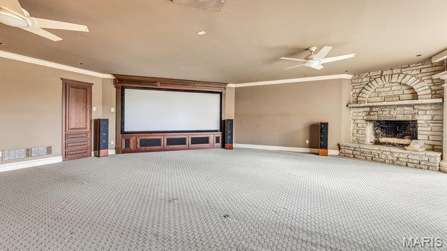 962 Hwy W, Foristell, MO 63348 - carpeted home theater room with a ceiling fan, ornamental molding, and a stone fireplace