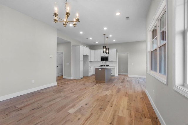 2224 Heywood Mdws, Cape Girardeau, MO 63701 - kitchen with stainless steel microwave, a chandelier, baseboards, recessed lighting, and a kitchen island with sink