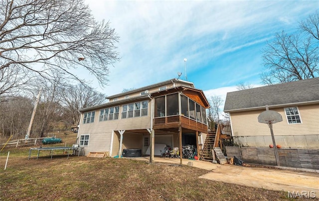 22125 Teak Ln, Saint Robert, MO 65584 - back of property featuring a sunroom, a trampoline, a garage, stairs, and concrete driveway