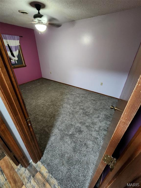 22125 Teak Ln, Saint Robert, MO 65584 - spare room featuring ceiling fan, a textured ceiling, and carpet