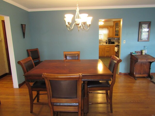 1856 E Broadway, Alton, IL 62002 - dining area featuring wood finished floors, a chandelier, ornamental molding, and baseboards