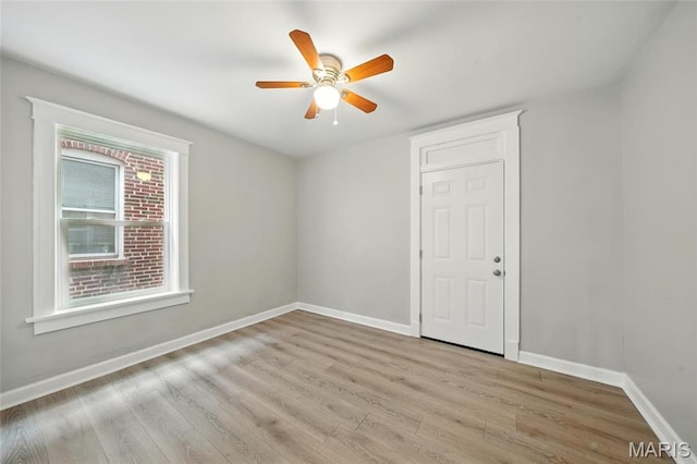 spare room featuring wood finished floors, baseboards, and a ceiling fan