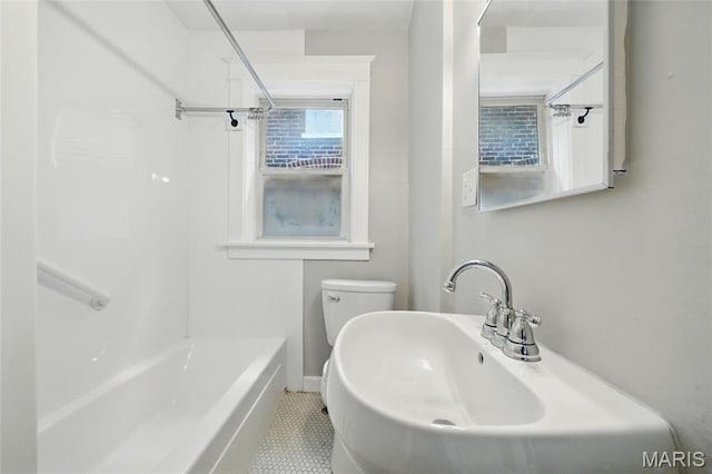 bathroom with toilet, tile patterned flooring, baseboards, and a sink