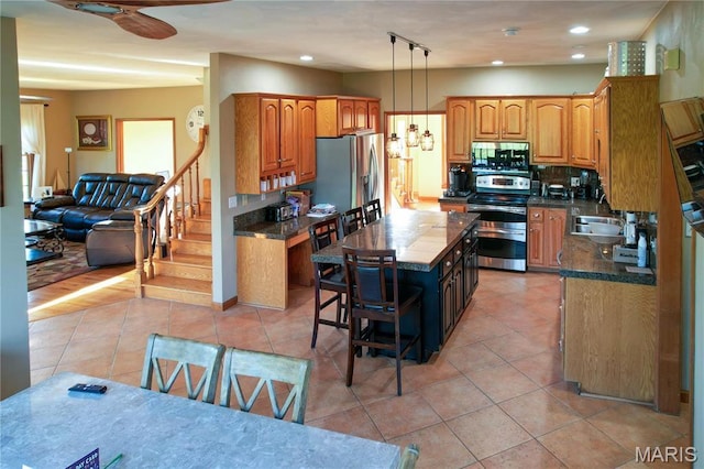 334 Spring Lake Rd, Millstadt, IL 62260 - kitchen with stainless steel appliances, light tile patterned flooring, a center island, a sink, and pendant lighting
