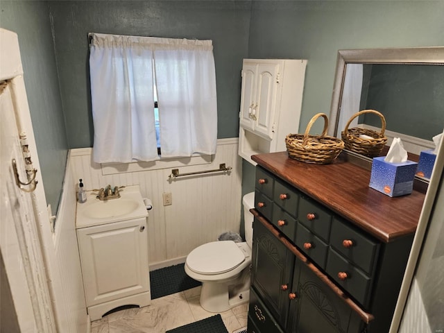 174 Clinton St, Hamburg, IL 62045 - bathroom with marble look tile flooring, vanity, wainscoting, and toilet