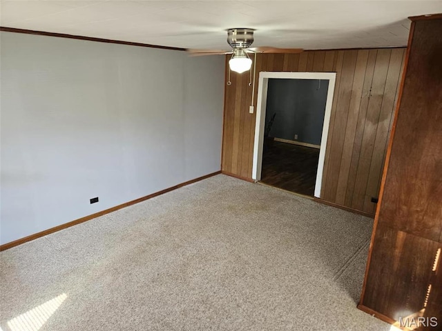 174 Clinton St, Hamburg, IL 62045 - spare room featuring carpet flooring, a ceiling fan, wooden walls, and crown molding