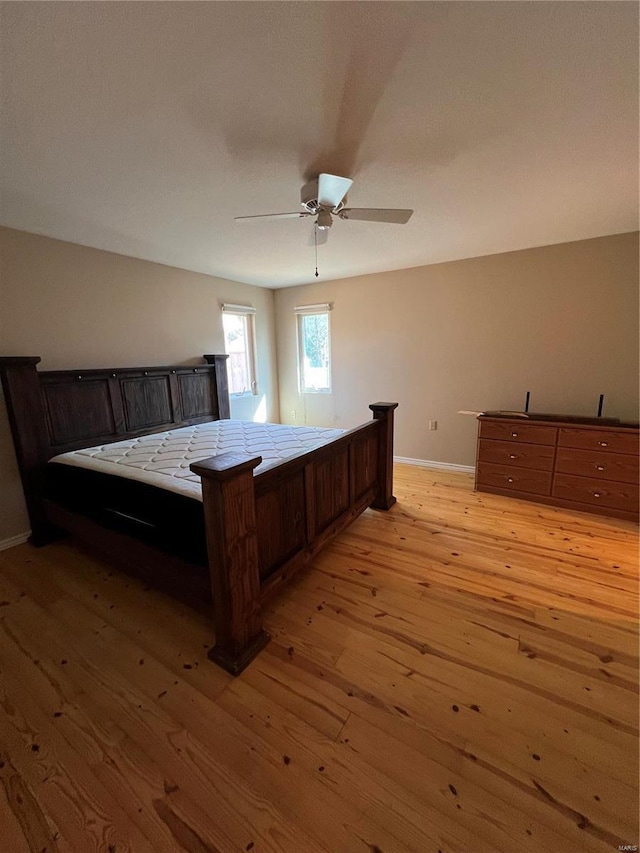 bedroom featuring light wood-style flooring, baseboards, and a ceiling fan