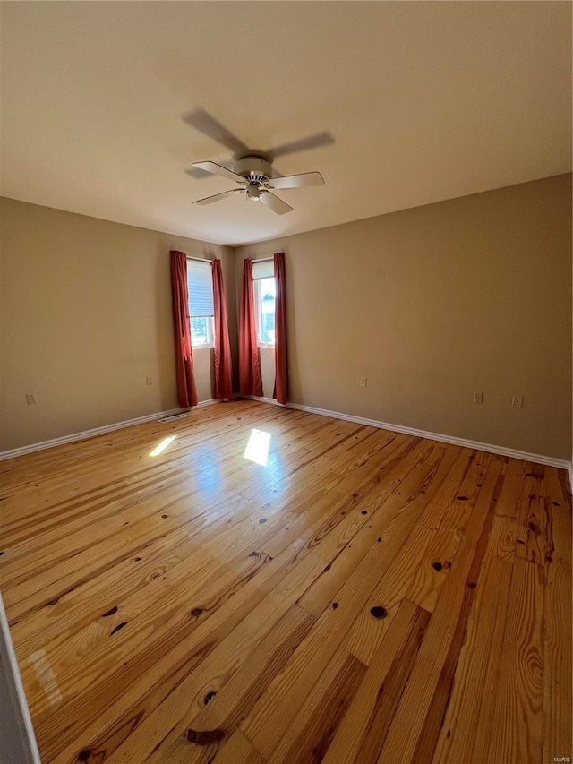 unfurnished room featuring ceiling fan, wood finished floors, and baseboards