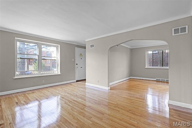 7273 Dartmouth Ave, Saint Louis, MO 63130 - unfurnished room featuring arched walkways, healthy amount of natural light, wood finished floors, baseboards, and ornamental molding