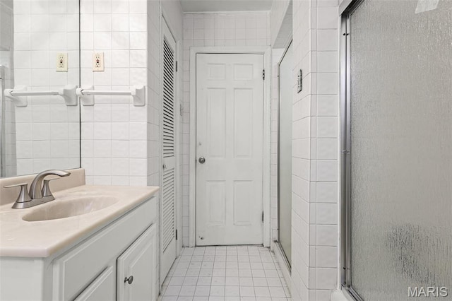 7273 Dartmouth Ave, Saint Louis, MO 63130 - bathroom with a stall shower, tile patterned floors, vanity, and tile walls