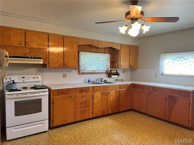 1402 W Randolph St, Vandalia, IL 62471 - kitchen with white electric range oven, under cabinet range hood, a ceiling fan, and light countertops