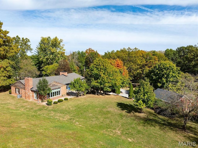 aerial view of property and surrounding area with a heavily wooded area