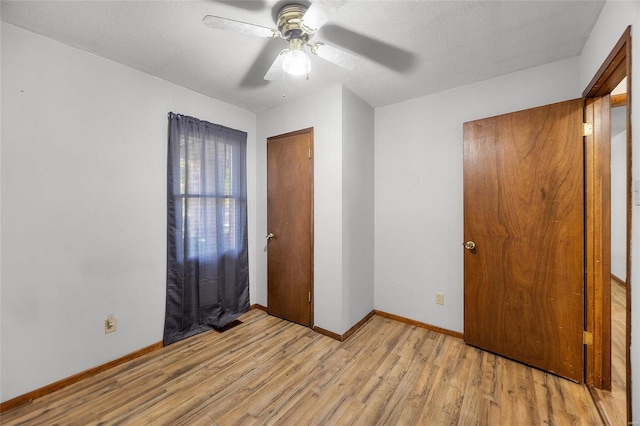 1145 Danby Rd, Festus, MO 63028 - unfurnished bedroom featuring light wood-type flooring, baseboards, ceiling fan, and a textured ceiling