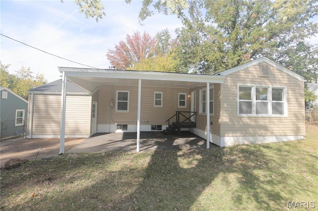8912 Boyce Pl, Saint Louis, MO 63136 - rear view of property with driveway, a carport, and a yard