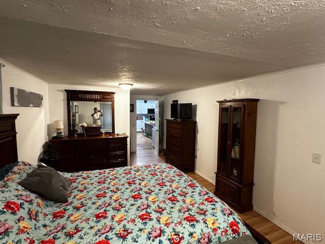 699 State Highway V, Sturdivant, MO 63782 - bedroom featuring wood finished floors and a textured ceiling