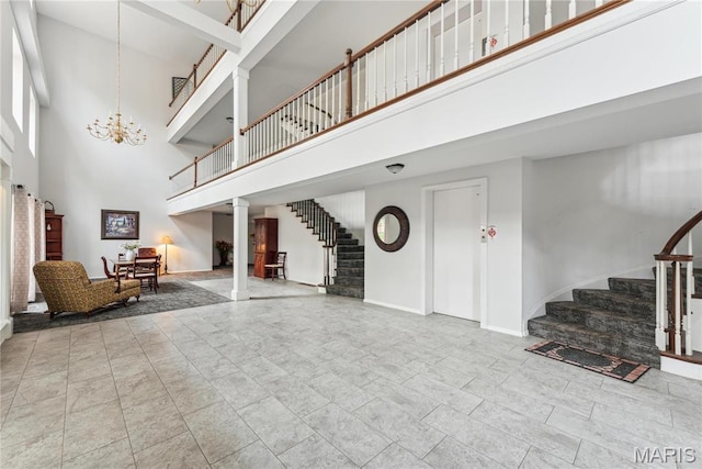 964 Claytonbrook Dr Unit 2A, Ballwin, MO 63011 - living room with stairway, a towering ceiling, a chandelier, baseboards, and ornate columns