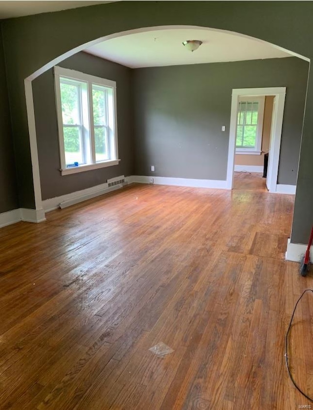 12540 Bellefontaine Rd, Saint Louis, MO 63138 - spare room with wood finished floors, baseboards, and arched walkways