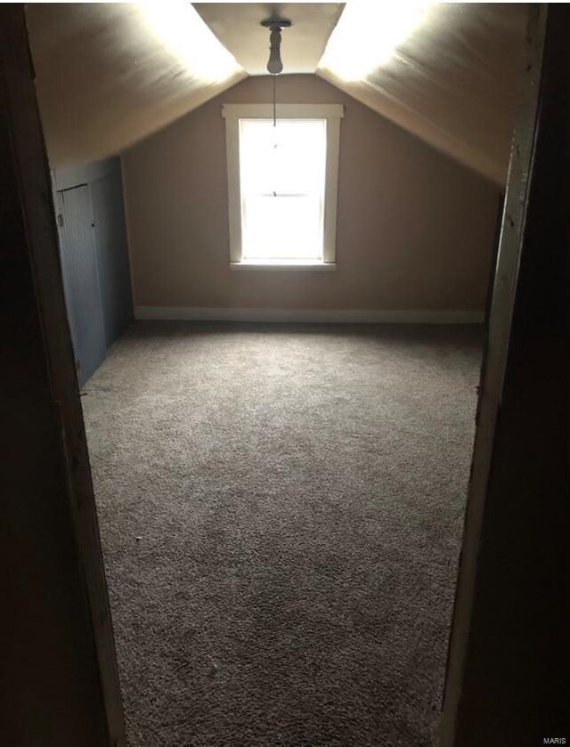 12540 Bellefontaine Rd, Saint Louis, MO 63138 - bonus room with dark colored carpet, baseboards, and vaulted ceiling