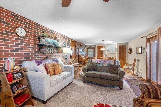 living room featuring ceiling fan, brick wall, and carpet