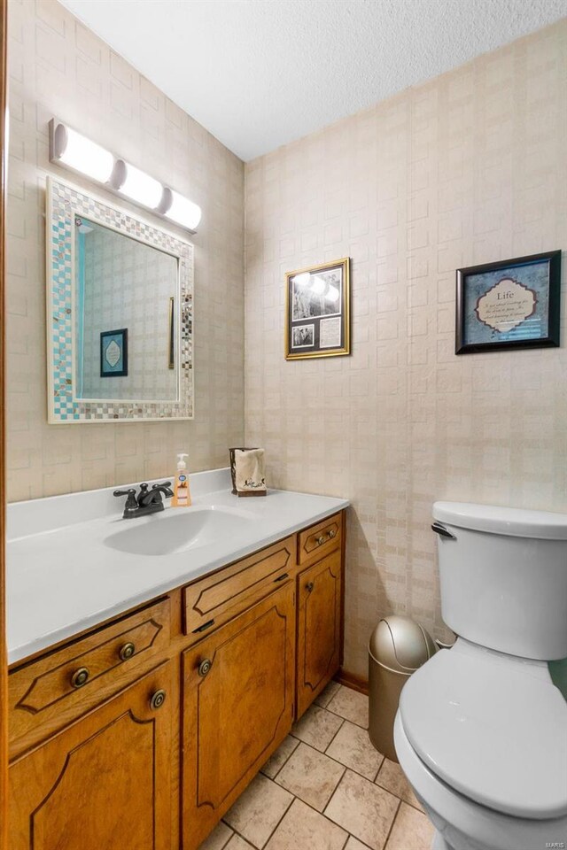 bathroom with toilet, vanity, and a textured ceiling