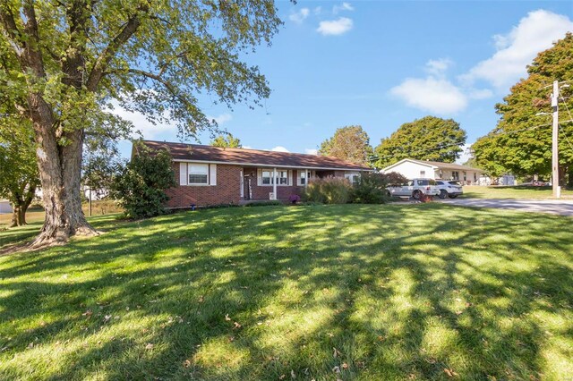 view of front of home featuring a front yard and brick siding