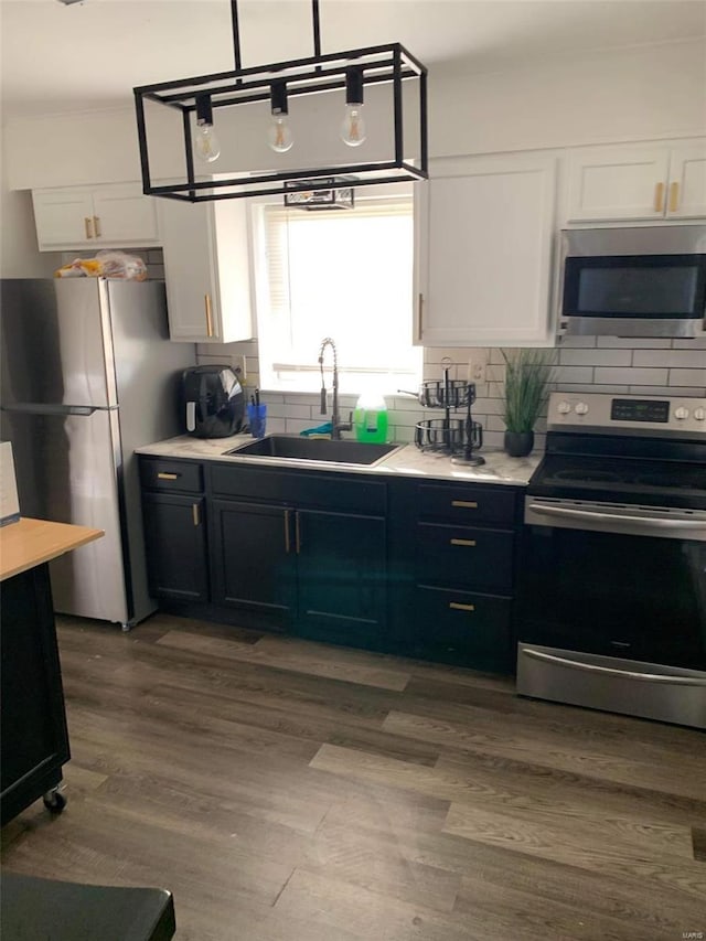 11821 Larimore Rd, Saint Louis, MO 63138 - kitchen with stainless steel appliances, a sink, white cabinetry, backsplash, and light countertops