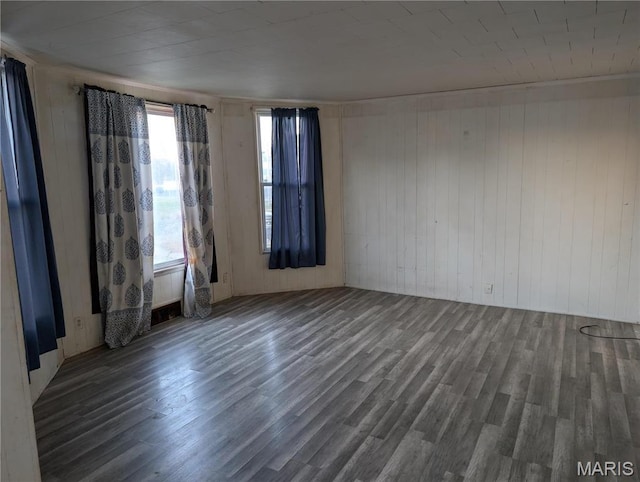 unfurnished room with wood finished floors and wooden walls