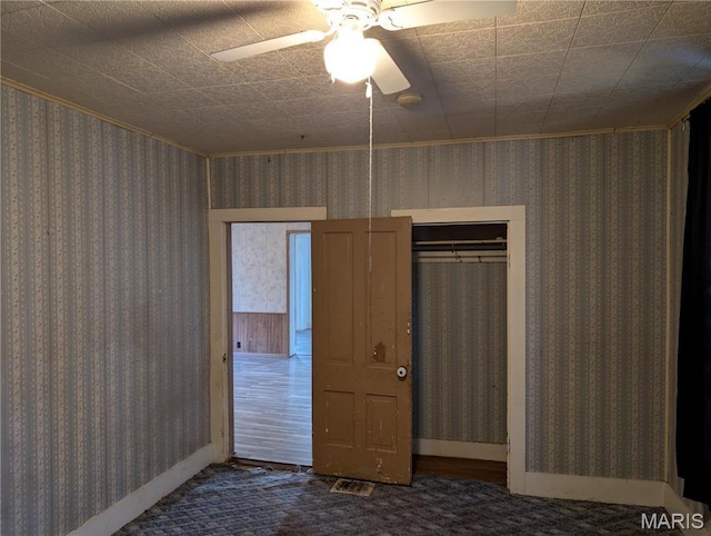 unfurnished bedroom with ceiling fan, carpet floors, and baseboards