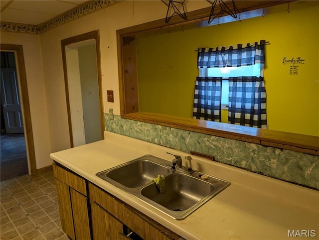 kitchen featuring a sink, brown cabinets, and light countertops