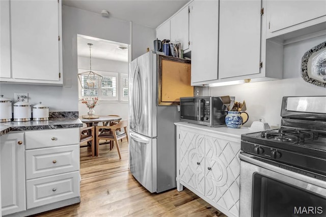 11409 Manchester Rd, Saint Louis, MO 63122 - kitchen with appliances with stainless steel finishes, white cabinets, light wood-type flooring, and dark countertops