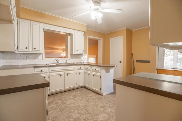 12191 County Road 637, Dexter, MO 63841 - kitchen with a sink, decorative backsplash, white cabinetry, ceiling fan, and ornamental molding