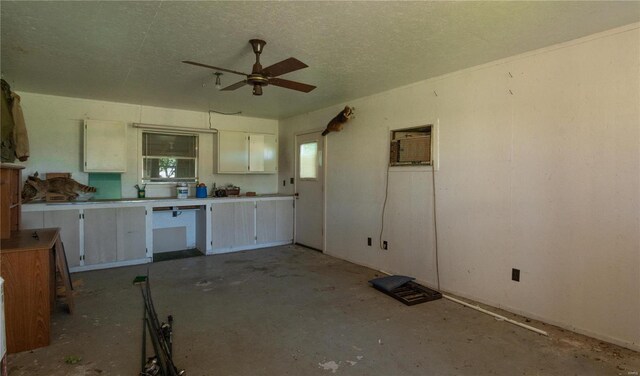 12191 County Road 637, Dexter, MO 63841 - kitchen featuring a ceiling fan, white cabinets, a wall mounted air conditioner, concrete flooring, and a textured ceiling